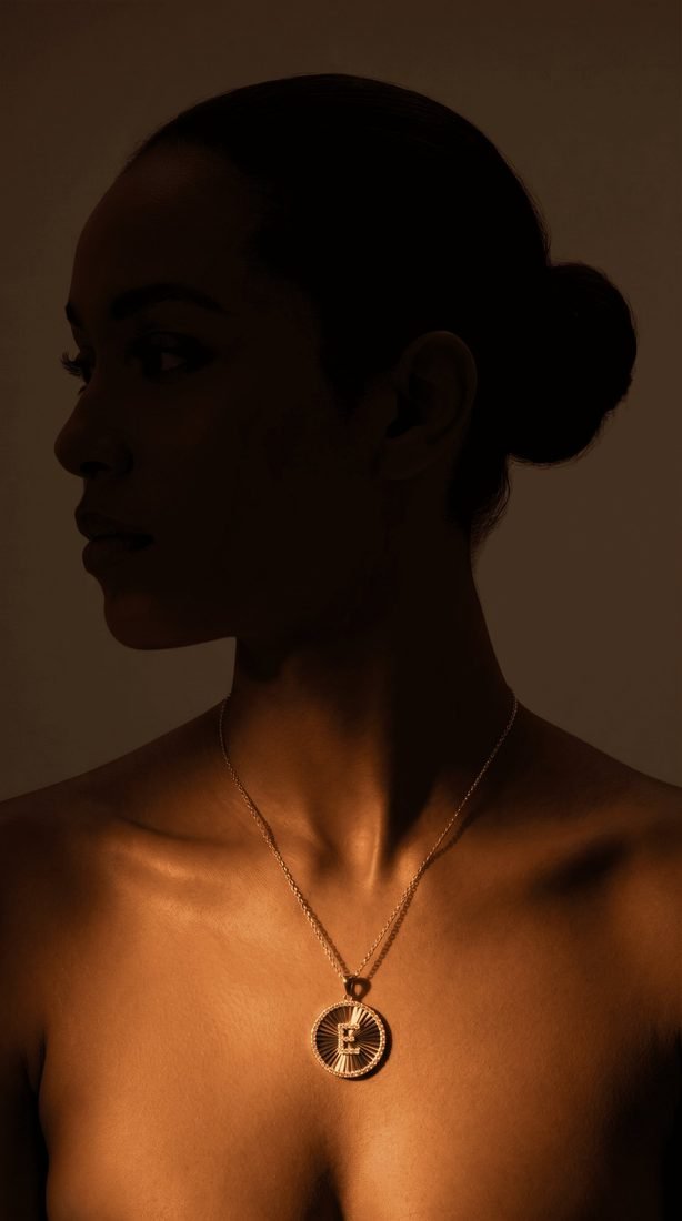 Gold initial pendant in dramatic light